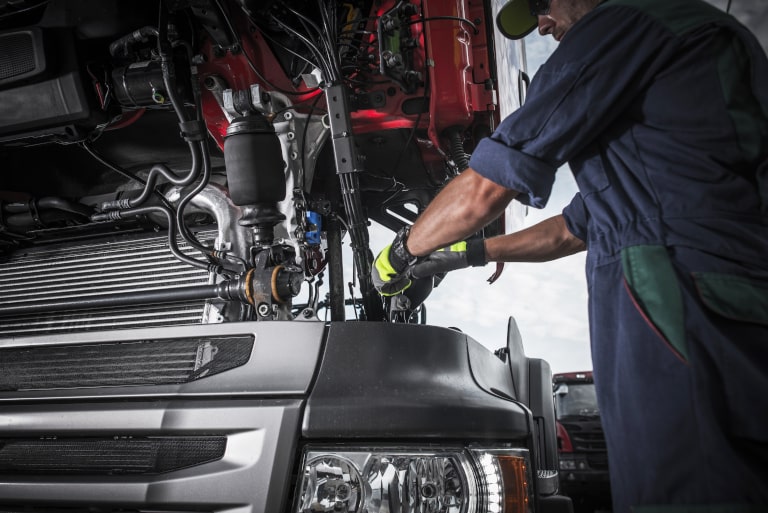 Diesel mechanic working on a lease purchase trucking company semi truck