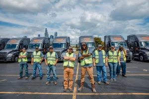 Group of Nova Lines flatbed truck drivers standing in front of their semi trucks
